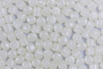 White plastic beads on wood  background, Polymers bead or polymer resin, polymer pallet, Product from petrochemical plants. granules polymer,
