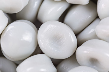 White plastic beads on wood  background, Polymers bead or polymer resin, polymer pallet, Product from petrochemical plants. granules polymer,