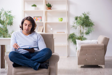 Young male student preparing for exams at home