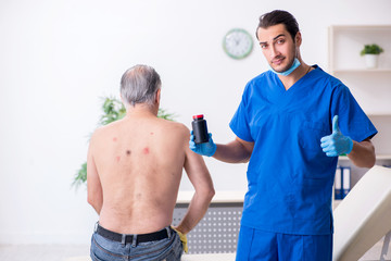 Old man visiting young male doctor dermatologist