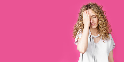 A young woman holds on to her sore head. Female portrait.