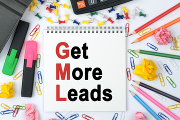 On the table is a calculator, diary, markers, pencils and a notebook with the inscription - Get More Leads