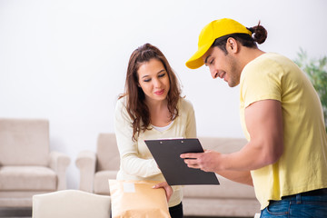 Young male courier delivering parcel to the office