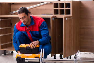 Young handsome male carpenter working indoors