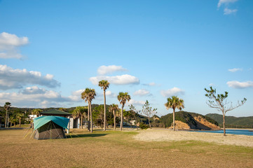 種子島の奇岩のある美しい浜辺、熊野海水浴場でキャンプテントをしている景色