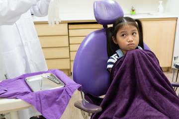 young asian girl feel scared to let dentist clean her tooth in dental clinic. dentistry and...