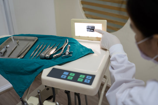 asian dentist showing computer tomography or ct scan of young patient in the dental clinic. dentistry and healthcare concept