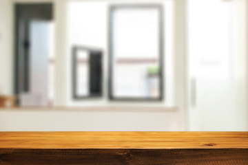 Wooden desk space and blurry background of home window for product display montage.