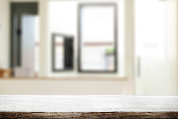 Wooden desk space and blurry background of home window for product display montage.