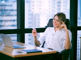 Fototapeta premium Professional Businesswoman sitting and chatting by using smartphone in office
