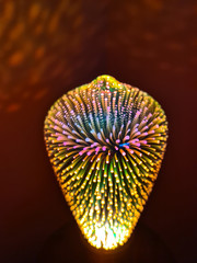 Glowing Iridescent coloured light bulb with blooming fireworks looking finish