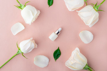 Natural organic homemade cosmetics concept. Skin care (therapy), beauty products: containers with face serum among delicate rose flowers petals on a pink background. Flat lay, top view, mock up