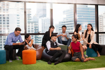 Fototapeta na wymiar Group of business people sitting and working or relaxing in workplace office or co-working space