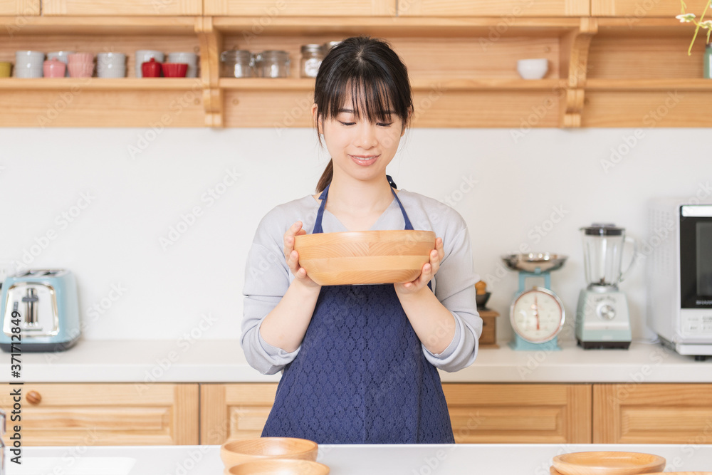 Wall mural エプロンをしてキッチンに立つ若い女性