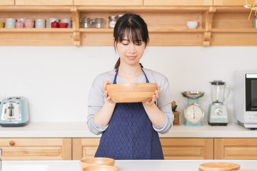 エプロンをしてキッチンに立つ若い女性