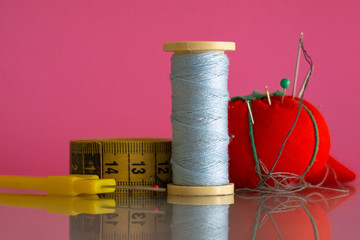 Sewing and textile repair materials on pink background
