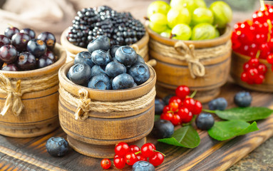 Ripe summer berries in a composition, on an old background.