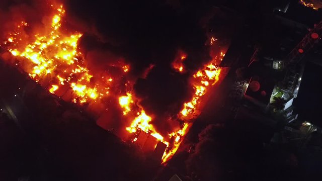 Aerial view around a building fire, aftermath of the bomb explosion, smoke rising, during night time, in Beirut, Lebanon - orbit, drone shot