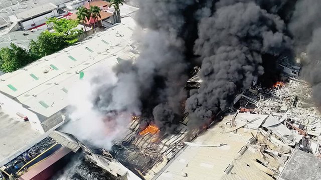 Aerial view of a building fire, aftermath of the bomb explosion, smoke rising, in Beirut, Lebanon - static, drone shot