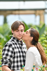 Fototapeta premium a young man receiving a kiss on the cheek from a young beautiful woman