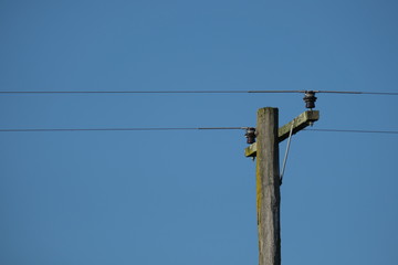 Electric poles with few wires and a clear sky