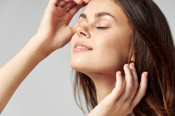 Obraz premium woman with closed eyes holding hands near face charm smile 