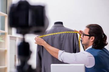 Young male tailor recording video for his blog