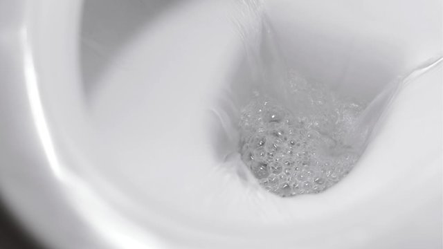 flushing water in the toilet bowl
