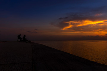 Fototapeta na wymiar silhouette of fishermen at the lake with twilight sky.
