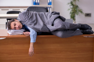 Young male employee sleeping in the office