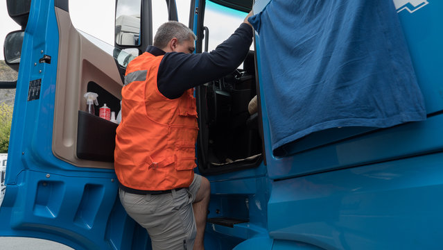 Man Climbing Into Cab Of European Truck.