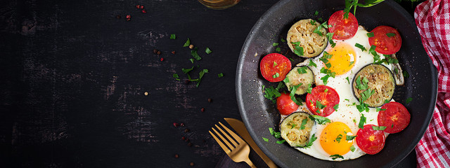 English breakfast - fried eggs, tomatoes and eggplant. American food. Top view, overhead, banner