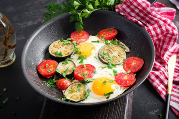 English breakfast - fried eggs, tomatoes and eggplant. American food.