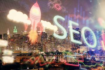 SEO hologram on city view with skyscrapers background double exposure. Search optimization concept.