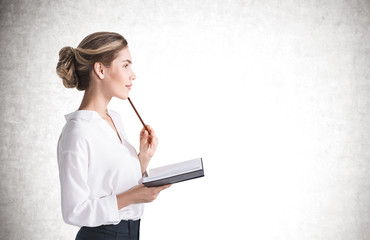 Thoughful young businesswoman with notebook