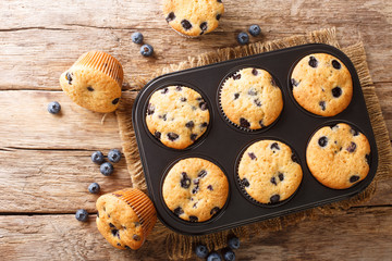 Rustic blueberry muffins close-up in a baking dish on the table. horizontal top view from above