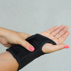 Wrist support with hand isolated on light background. Antimicrobial wrist brace