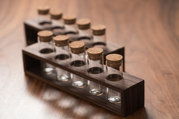 empty walnut holder with glass tubes for spices on walnut table surface