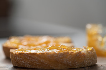 Ciabatta slices with orange marmalade on olive board