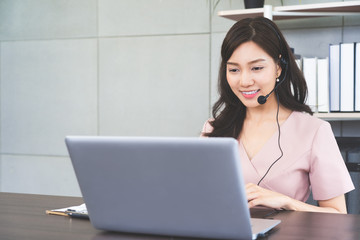 Young Asian busineswoman in headphone with computer pc having online vdo conference meeting at office,Telework concept