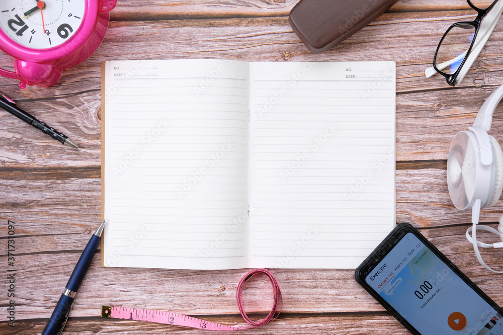 Poster Notebook and smartphone on wood table and space for text