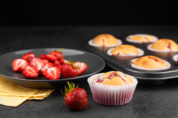Strawberry muffins with fresh berries on black background