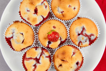 Strawberry muffins with fresh strawberries on white plate background