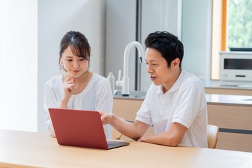 Obraz premium パソコンを見る 二人のアジア人 カップル 夫婦