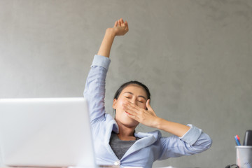 Business women are stretch oneself for relaxation on her desk