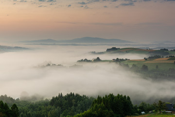 Fototapeta na wymiar Countryside and Meadows in Morning Fog and Mist at Beautiful Sunrise
