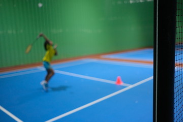 Fototapeta na wymiar Blur background with little girl training class badminton at gym.