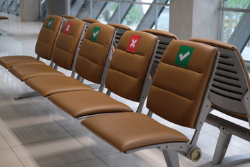 The seats at Airport marked for people to sit separately in response to slow down the spread of COVID-19. Social distancing measures concept.