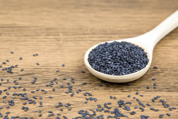 Black sesame seeds in a wooden spoon For healthy food and diet concepts.