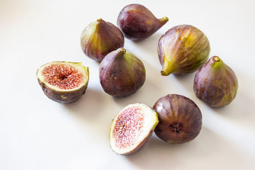Ripe figs, purple green. Whole fruits and cut with red flesh and seeds. Grey-blue background.
